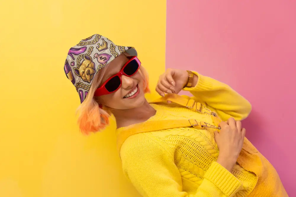 Neon Glam Bossbabe bucket hat with fashion and Bitcoin print worn by smiling woman in yellow outfit and red sunglasses